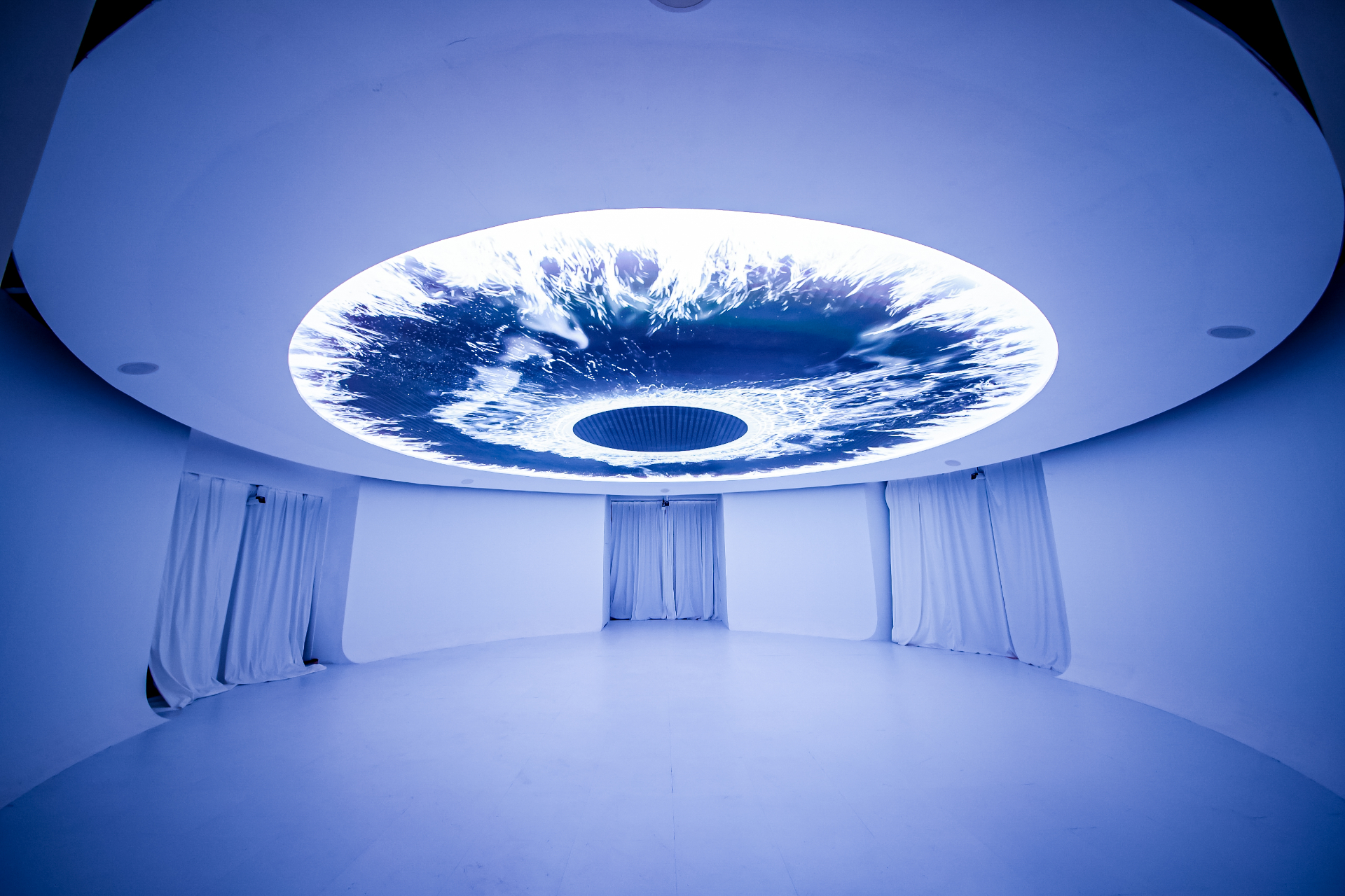 White immersive room with circular ceiling oculus
